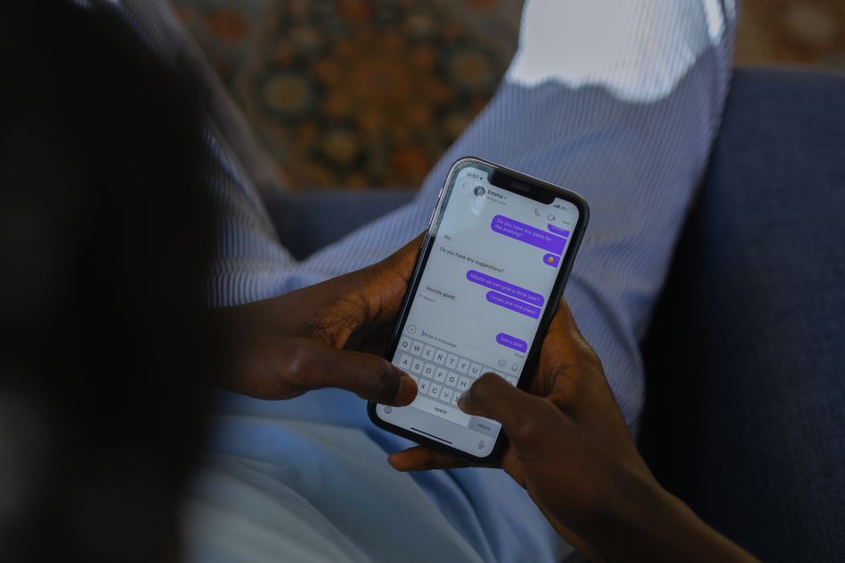 Hands holding a smartphone, typing a message