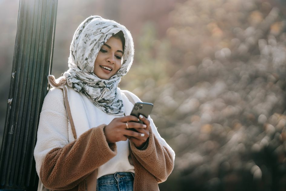 A woman text messaging on a smartphone in the city
