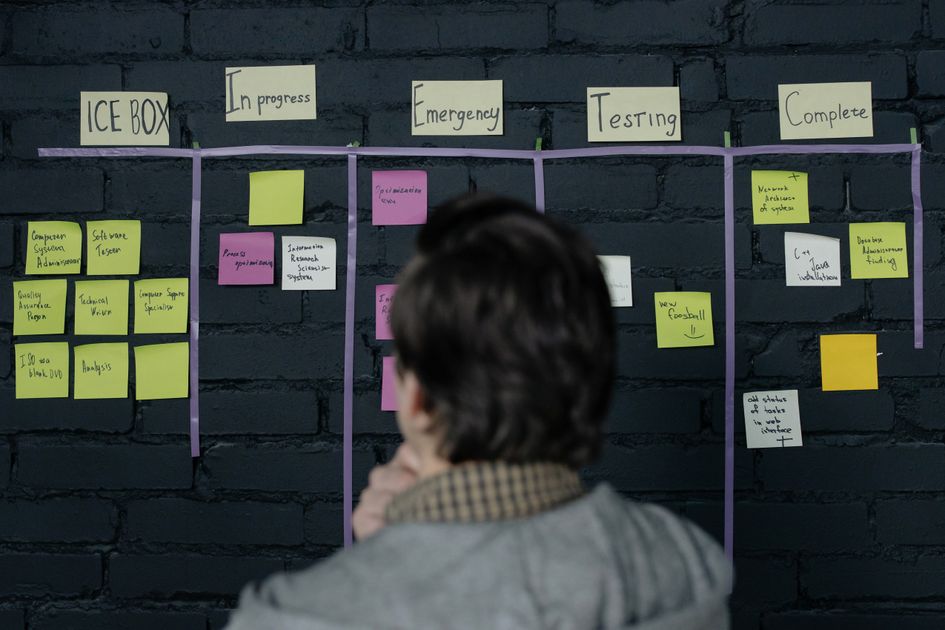 A man reviewing a scrum task board with sticky notes