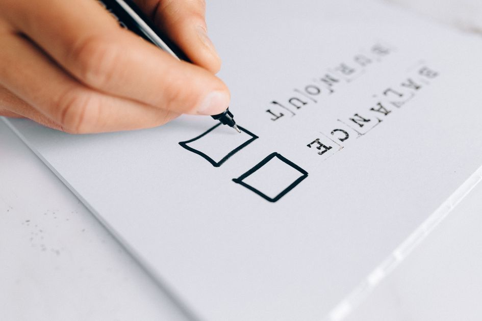 A hand drawing checkboxes on a checklist