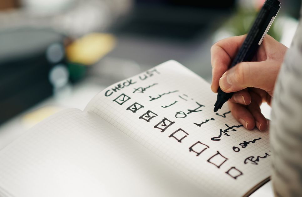 A hand writing tasks on a checklist