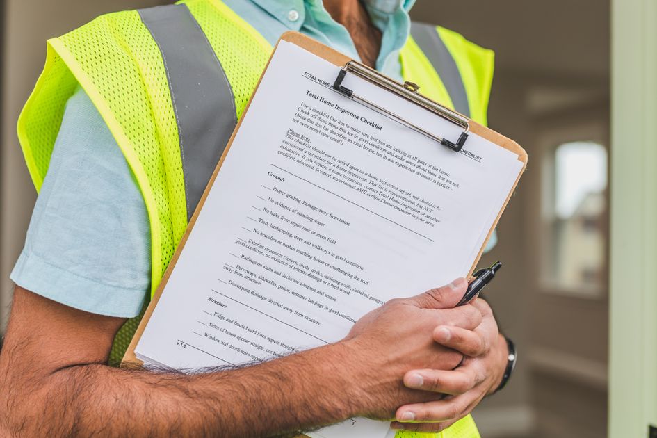 A person holding a checklist on a clipboard with a pen