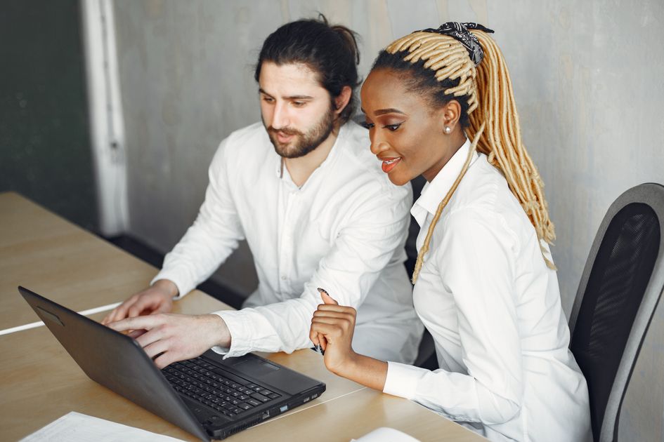 Two colleagues working together on a laptop
