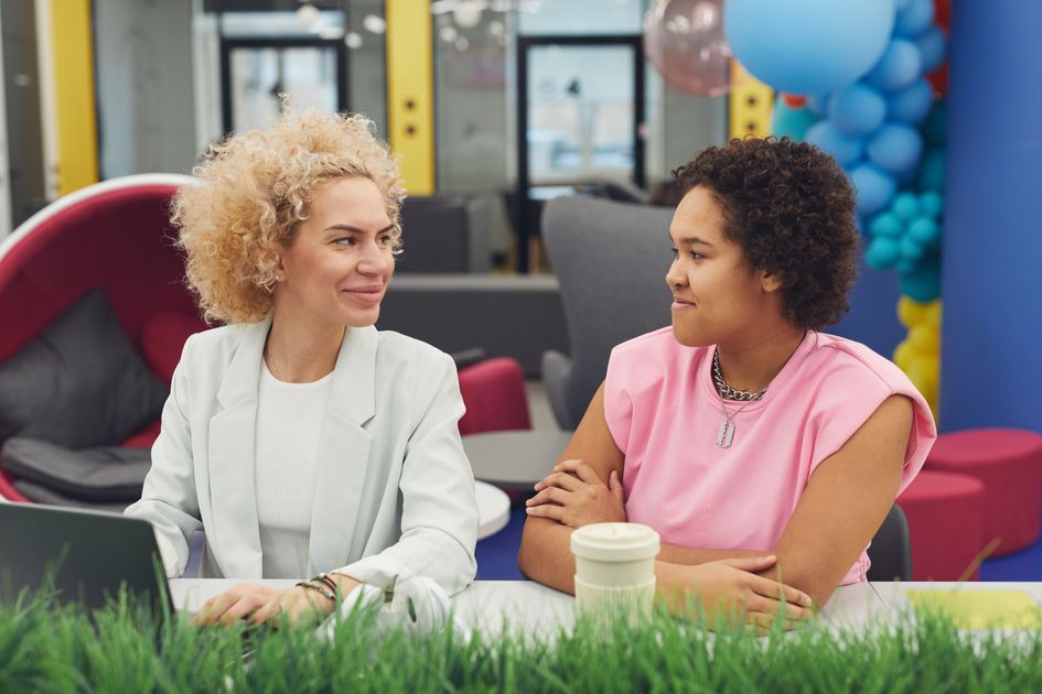 Two women having a discussion in a modern workspace