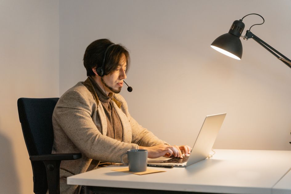 A businessman holding his head in frustration at a desk