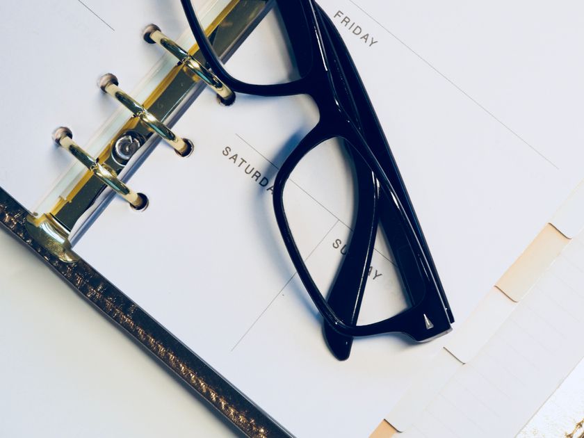 Eyeglasses resting on an open planner highlighting the weekend