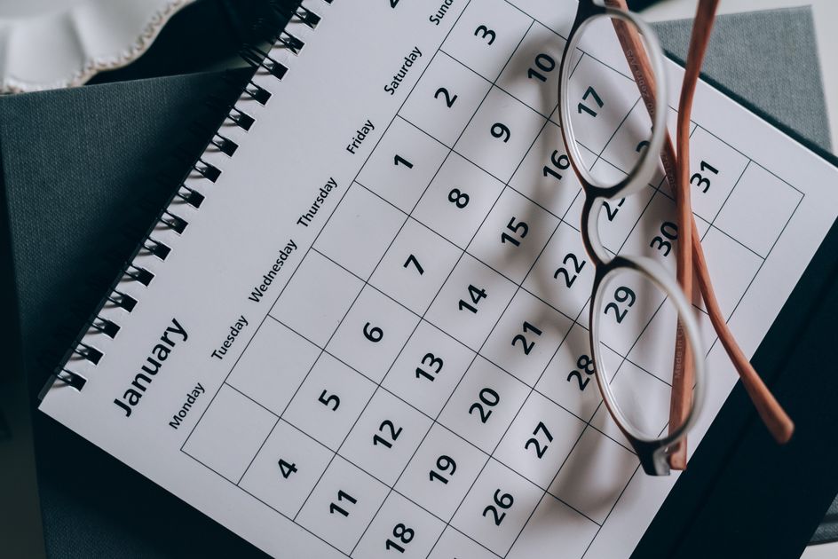 A calendar with eyeglasses on a table