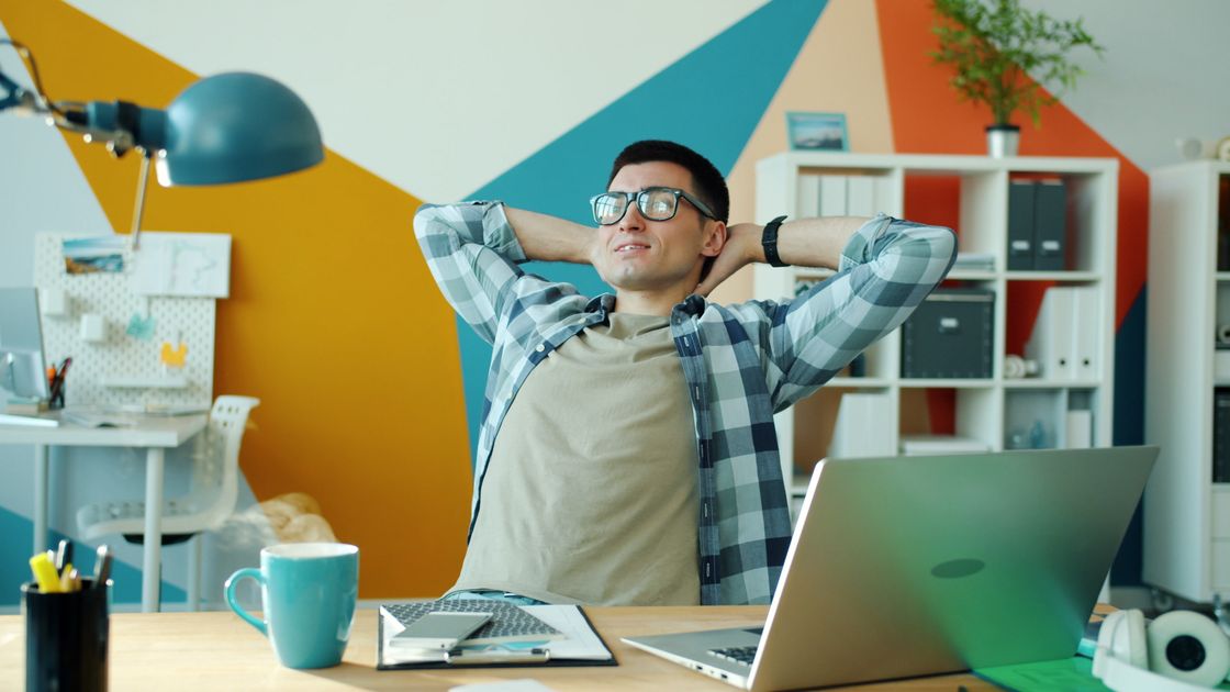 A person reviewing content on a laptop with a coffee nearby