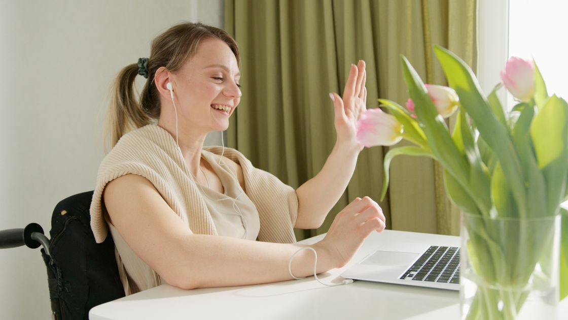 A person smiling on a video call with a laptop