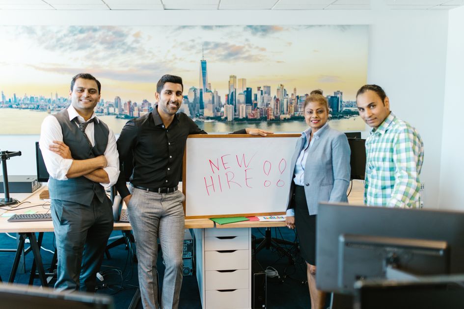A diverse team standing beside a whiteboard