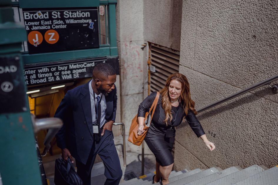 Two business professionals walking together at a station