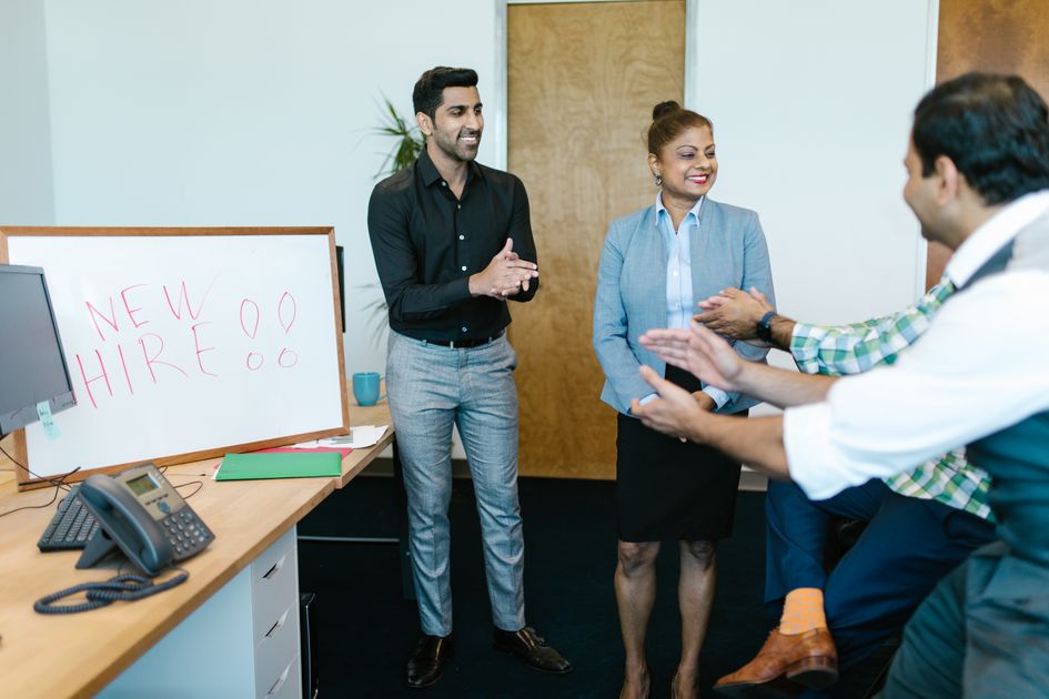 Colleagues applauding a new hire announcement in an office