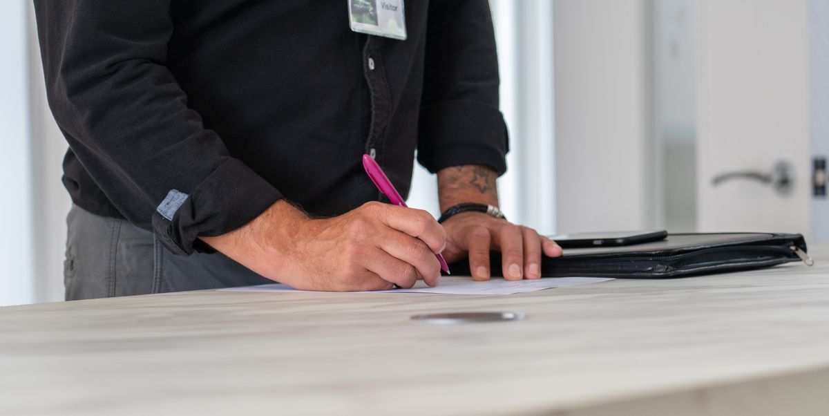 A businessman signing documents at a modern office desk