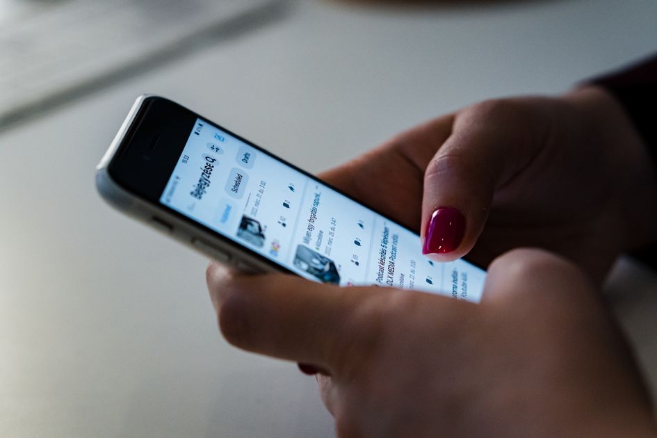 A person holding a smartphone browsing social media
