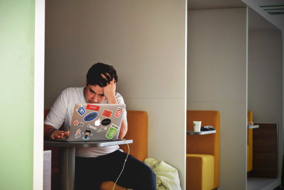 A stressed person working quickly on a laptop