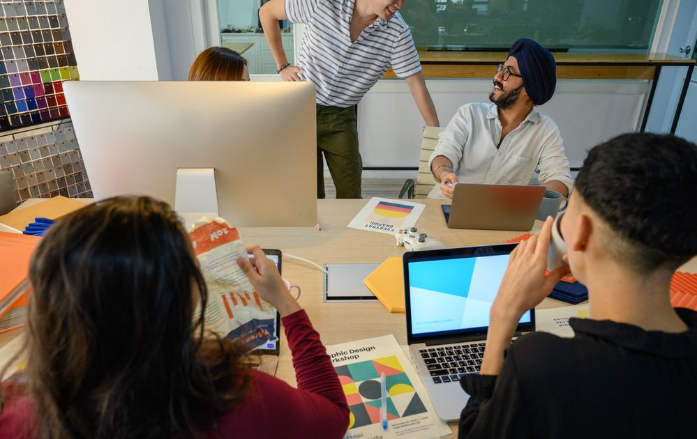 A group of professionals collaborating around a laptop