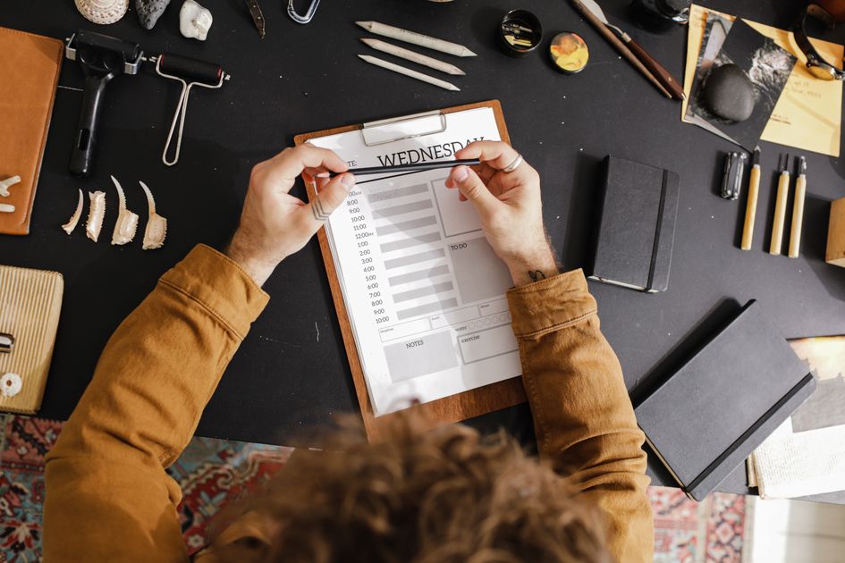 A creative workspace with a clipboard planner and art tools
