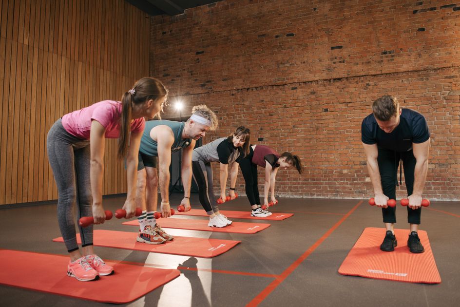 A group performing exercises together in a fitness studio