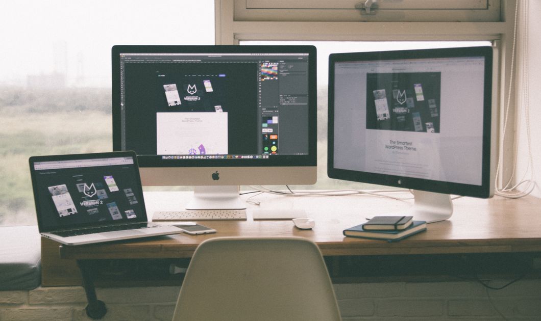 A workspace with multiple monitors, laptop and smartphone