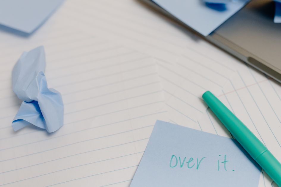 A desk with blue sticky notes and crumpled paper