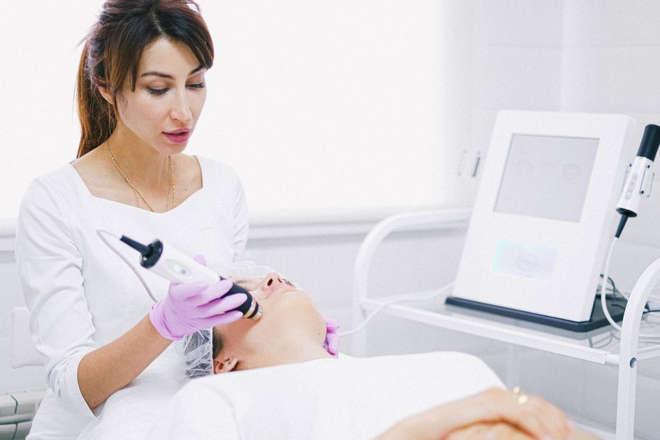 An aesthetician giving a laser facial treatment