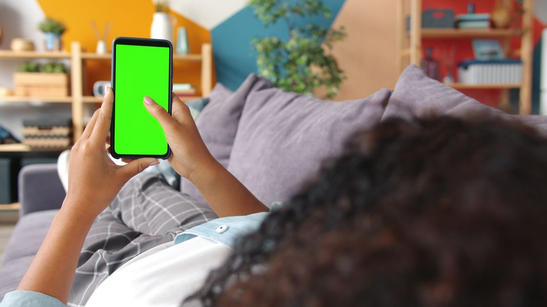 A woman relaxing on a couch using a smartphone