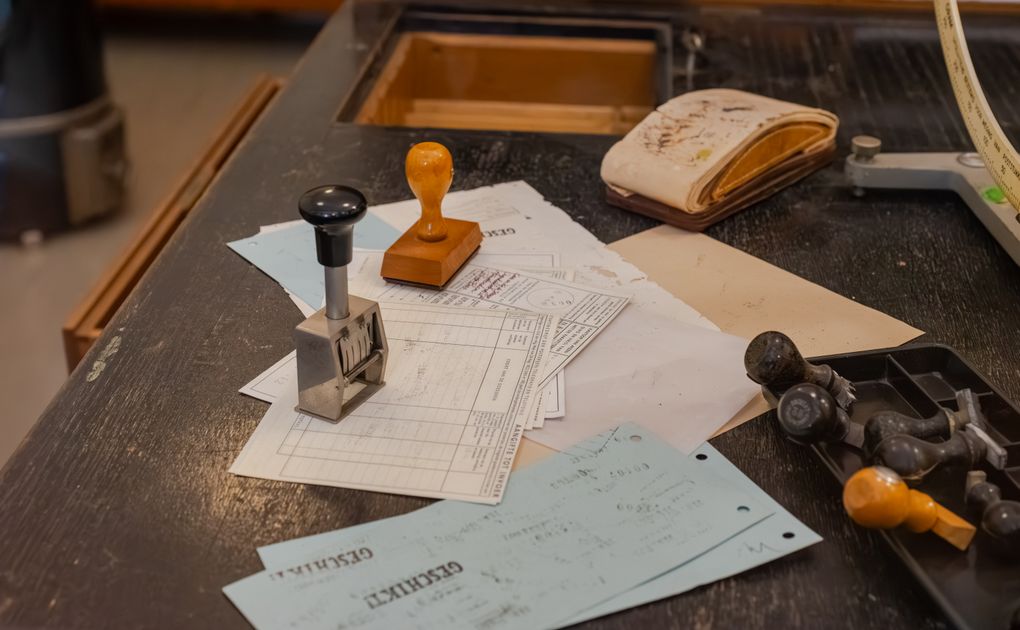 A cluttered desk with stamps and documents