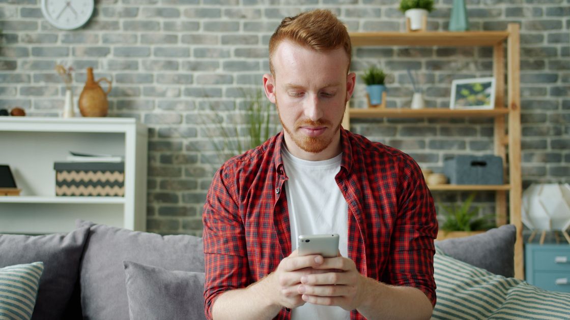 A man texting on a smartphone at home