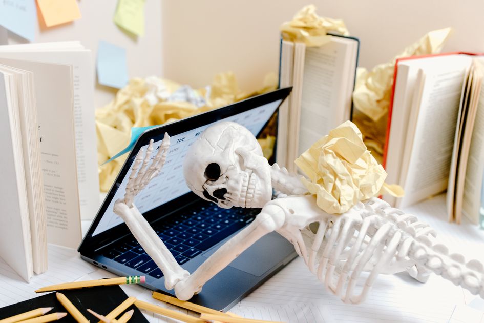 A worn-out desk scene surrounded by crumpled paper and books