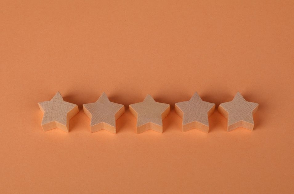 Five wooden star-shaped blocks arranged on an orange surface