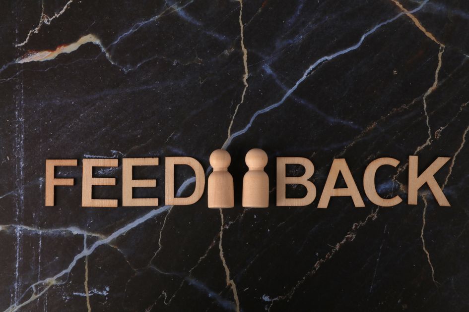Wooden figures with feedback text on a marble background