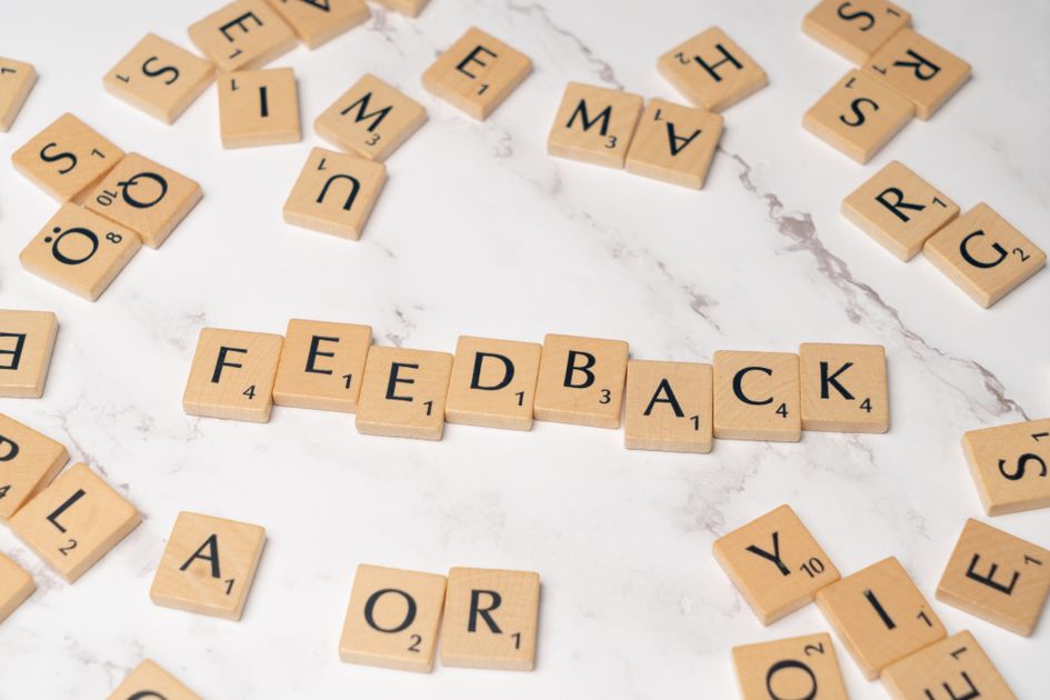 Wooden tiles arranged to spell Feedback on a marble background